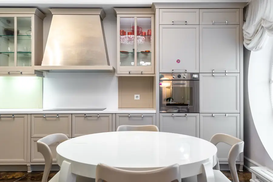 Cuisine rénovée avec meubles beiges et table ronde