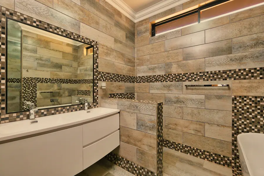 Salle de bain rénovée avec carrelage effet bois et double vasque
